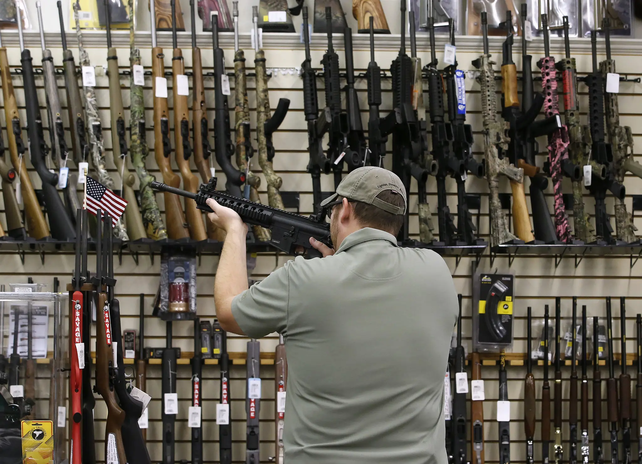 Licensed firearms specialist helping a customer select a rifle in-store