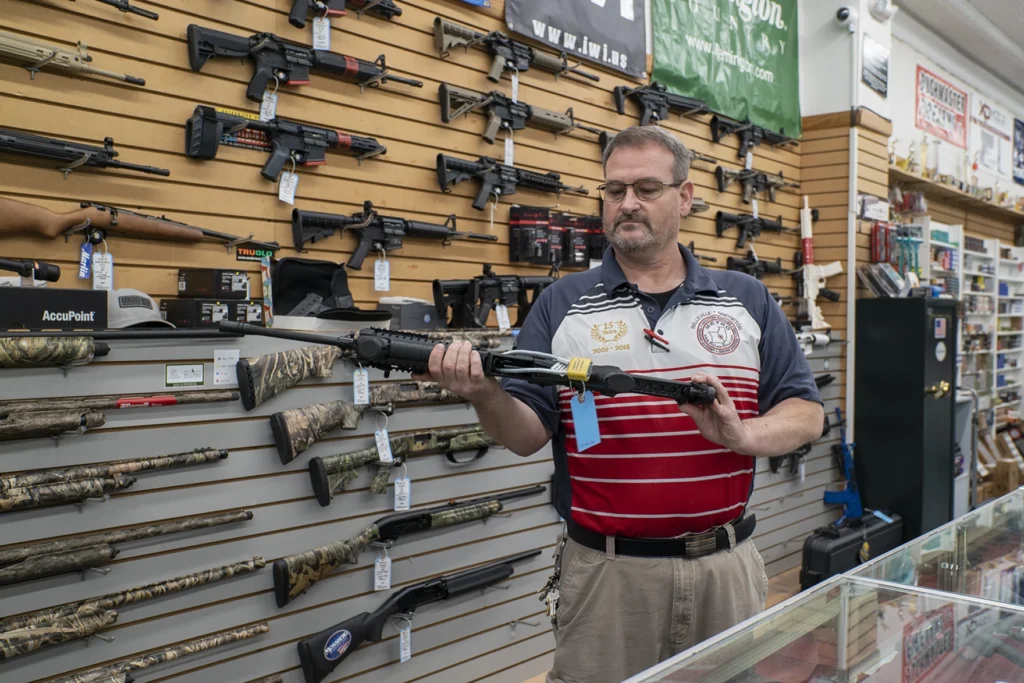 Store staff member helping a customer choose a firearm
